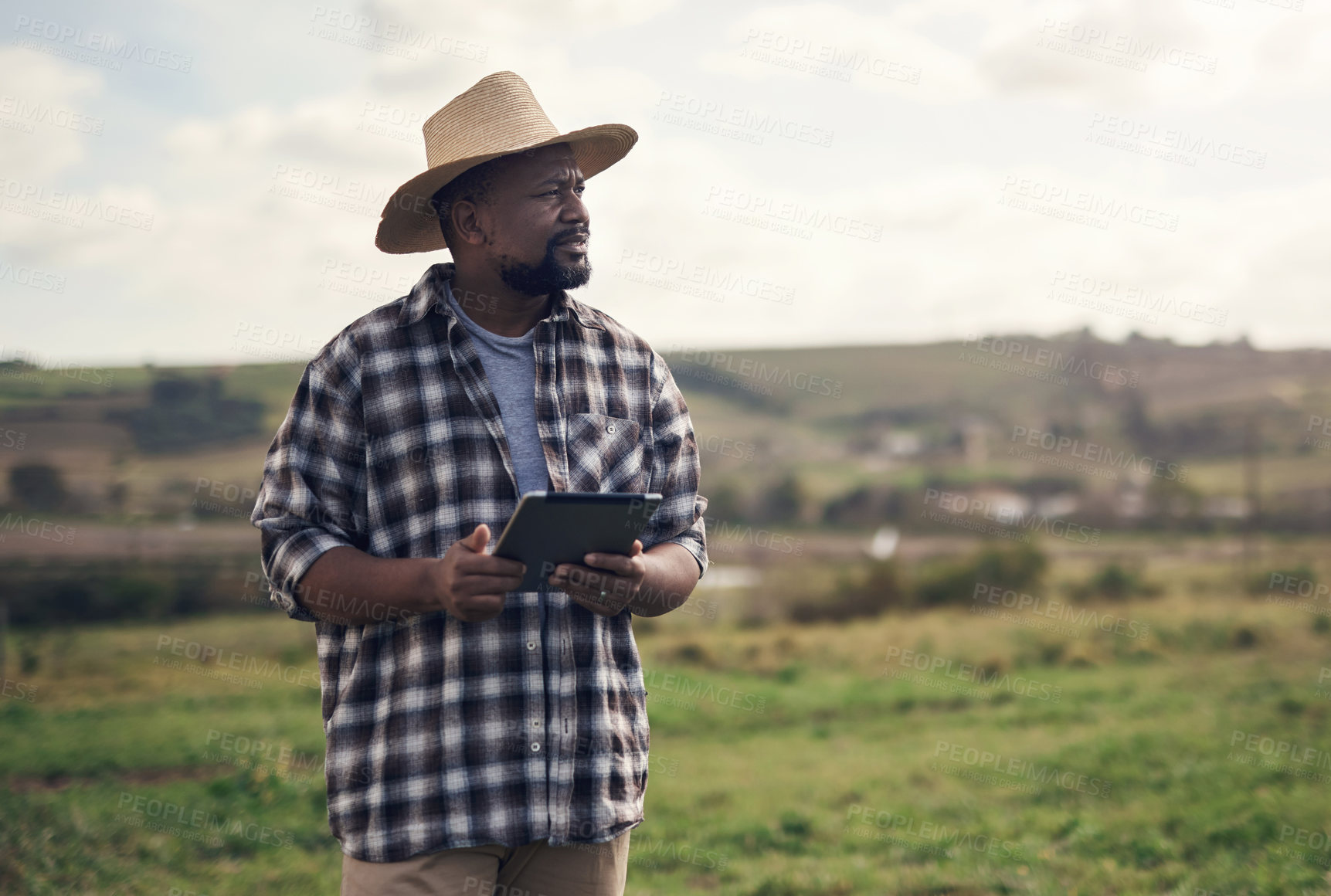 Buy stock photo Shot of a mature man using a digital tablet while working on a farm