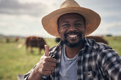 Buy stock photo Shot of a mature man giving a thumbs up and taking a selfie while working on a cow farm