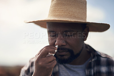 Buy stock photo Shot of a mature man using nasal spray while working on a farm