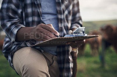 Buy stock photo Shot of an unrecognisable man writing notes while working on a cow farm