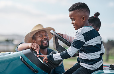 Buy stock photo Shot of a mature man helping his adorable son and daughter ride a tractor on a farm