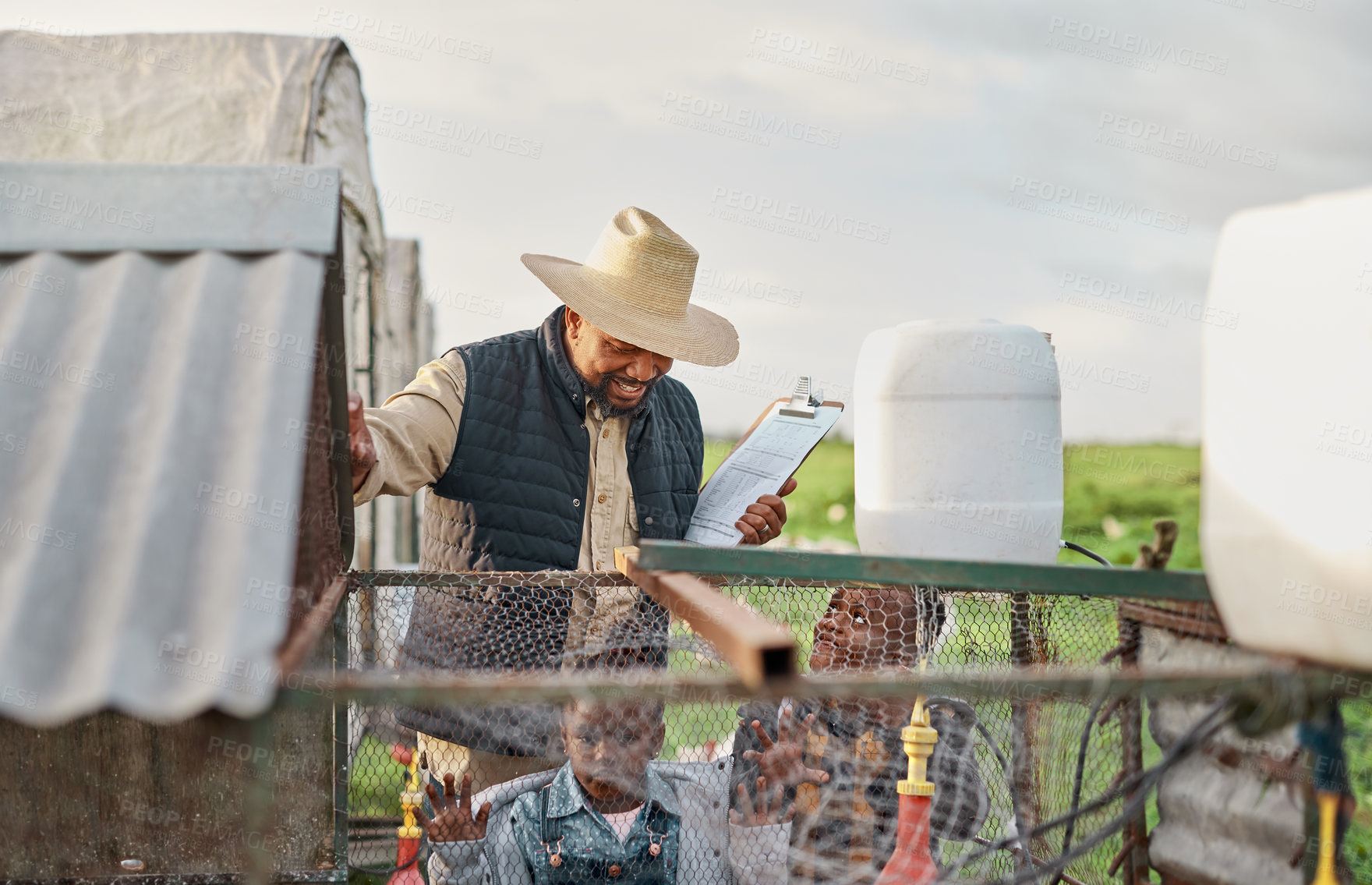 Buy stock photo Shot of a man working with his adorable son and daughter on a chicken farm