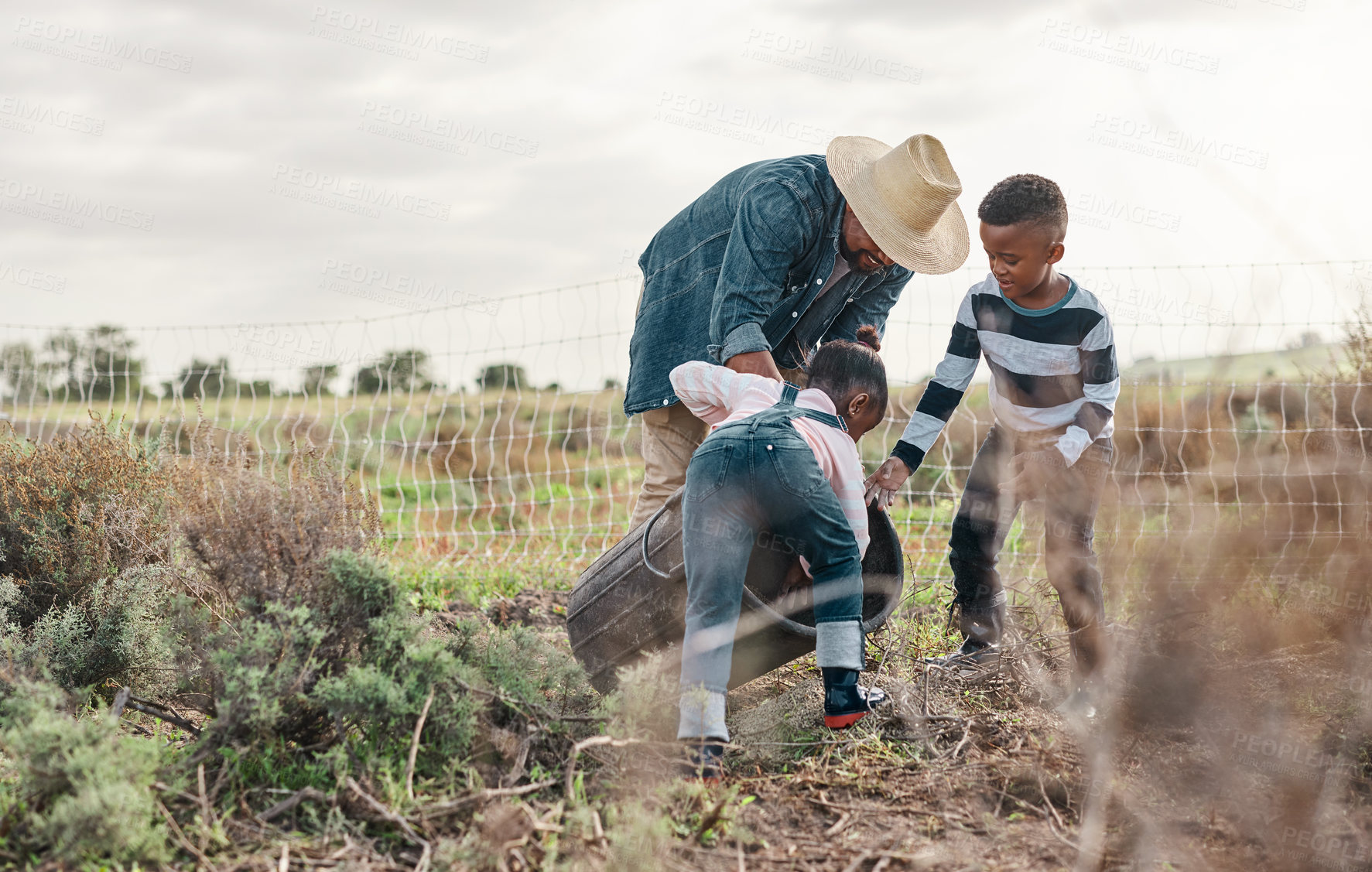 Buy stock photo Shot of a mature man working his adorable son and daughter on a farm