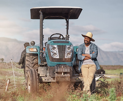 Buy stock photo Shot of a mature man standing next to his tractor on a farm