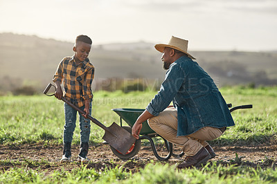 Buy stock photo Shot of a mature man working his adorable son on a farm