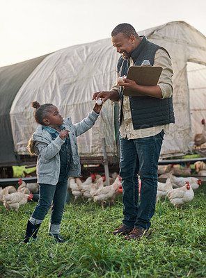 Buy stock photo Shot of a man working with his adorable daughter on a chicken farm