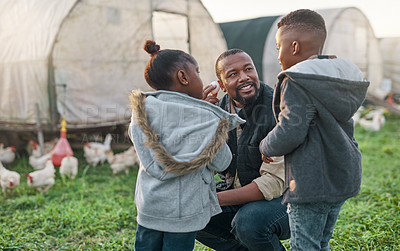 Buy stock photo Shot of a man working with his adorable son and daughter on a chicken farm