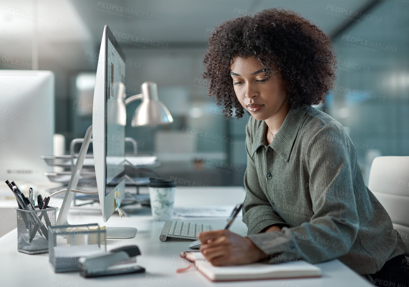 Buy stock photo Shot of a young focused female agent working in a call centre taking notes