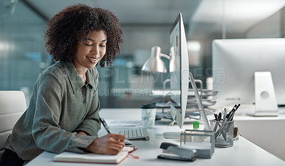 Buy stock photo Shot of a young female agent working in a call centre smiling while taking notes