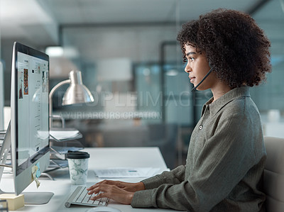 Buy stock photo Shot of a young female agent working in a call centre typing a keyboard