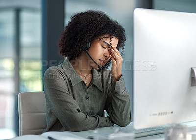 Buy stock photo Shot of a stressed young female agent taking a moment while working in a call centre