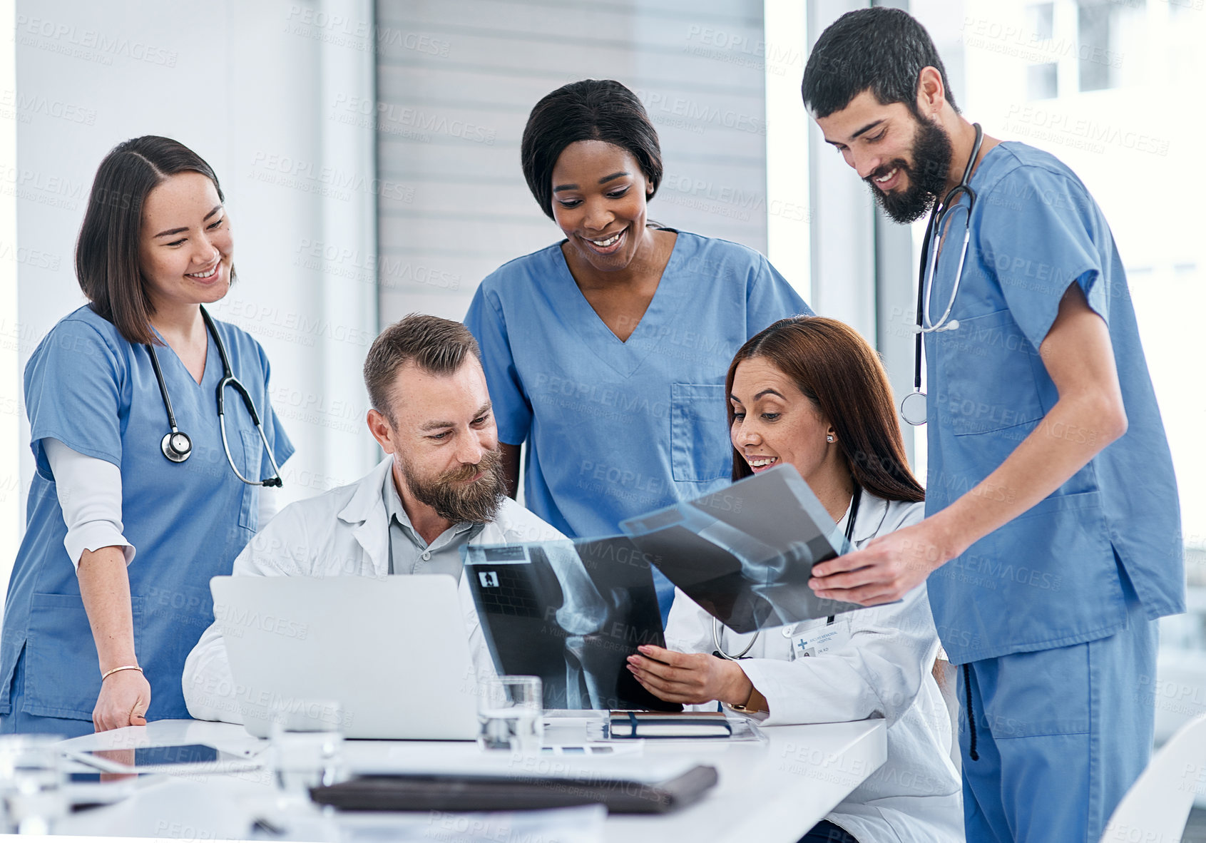 Buy stock photo Shot of a group of medical practitioners analysing x-rays in a hospital boardroom