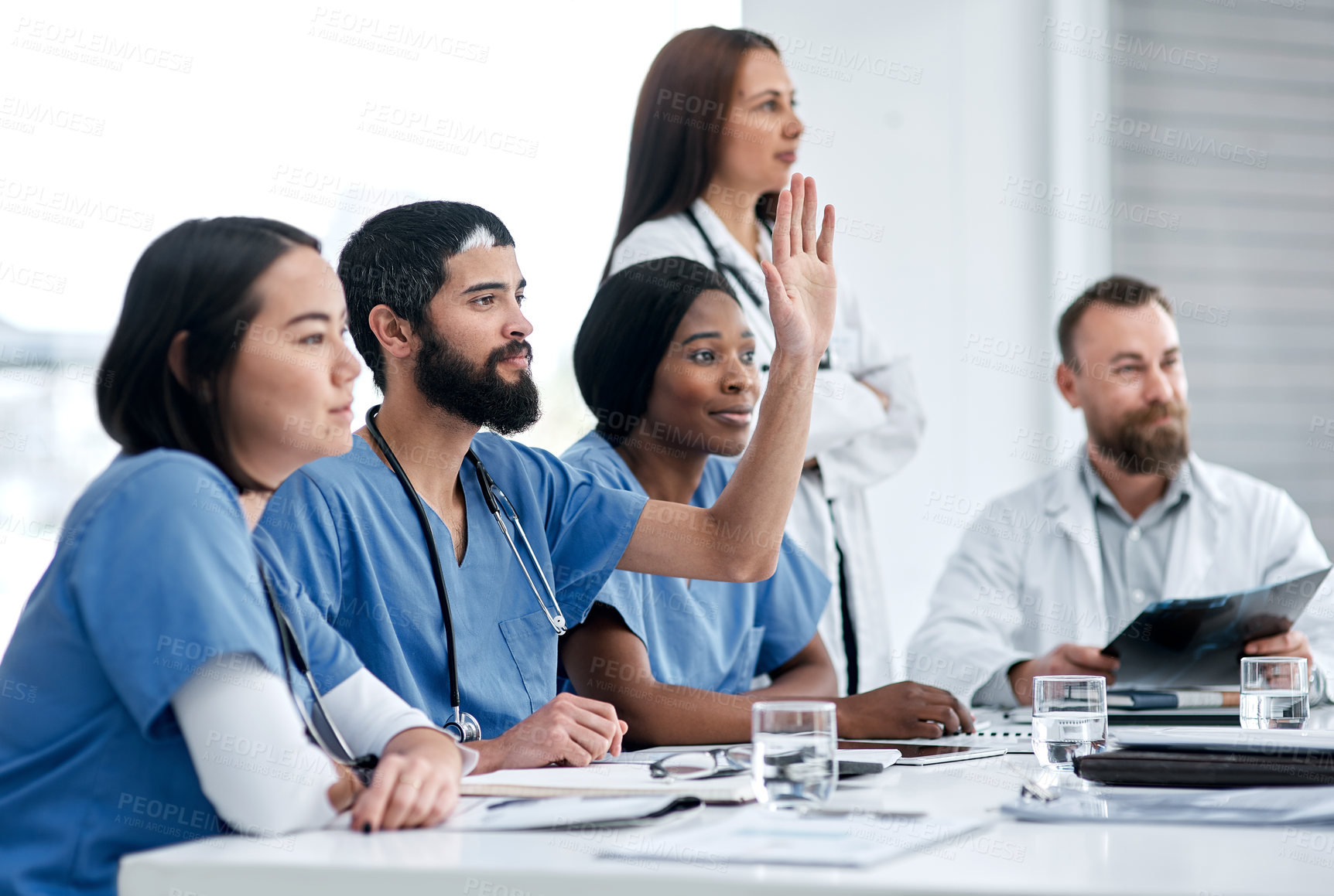 Buy stock photo Shot of a doctor raising his hand during a meeting in a hospital boardroom