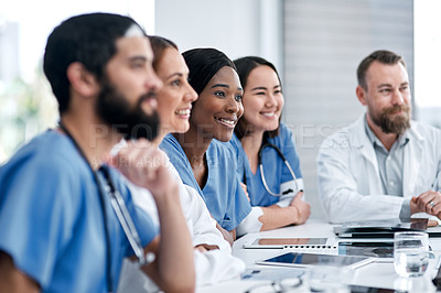 Buy stock photo Shot of a doctor sitting alongside her colleagues during a meeting in a hospital boardroom