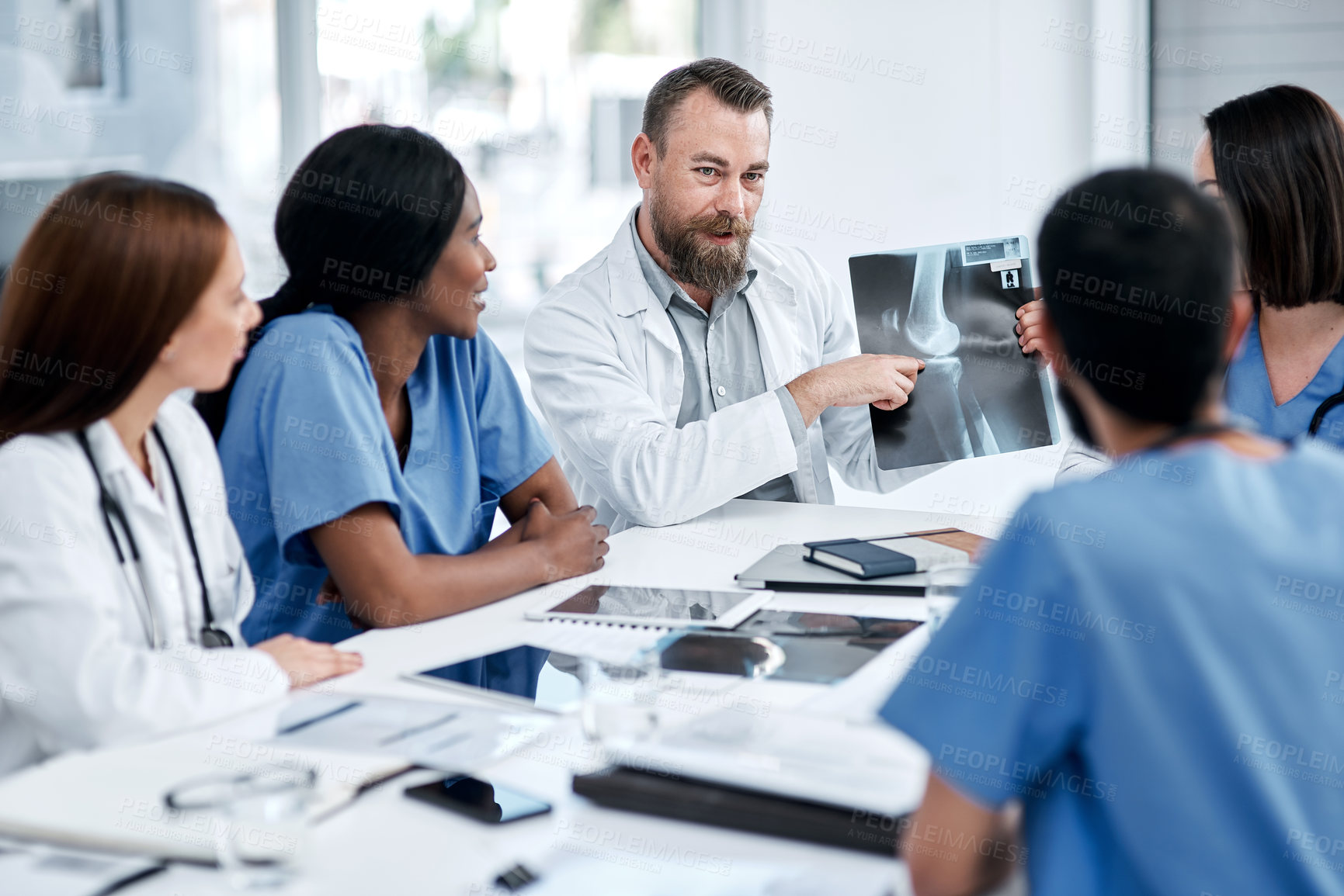 Buy stock photo Shot of a group of medical practitioners analysing x-rays in a hospital boardroom