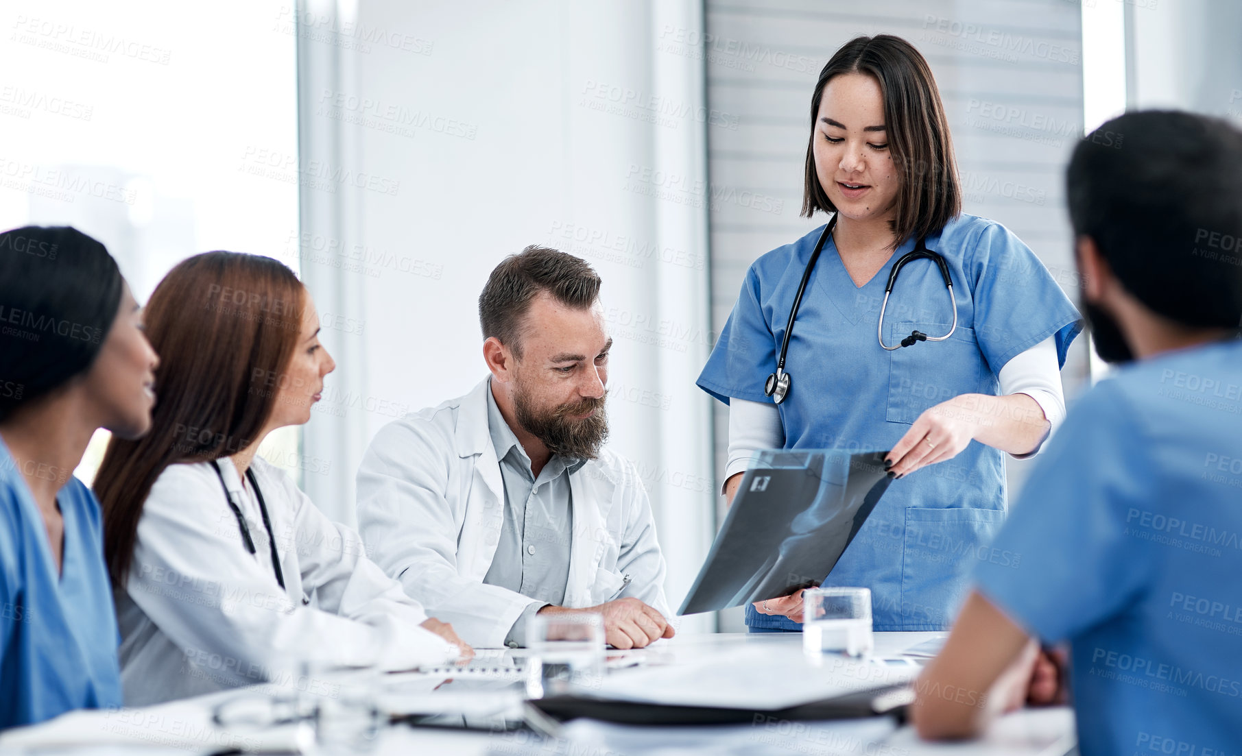 Buy stock photo Shot of a group of medical practitioners analysing x-rays in a hospital boardroom