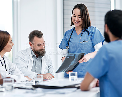 Buy stock photo Shot of a group of medical practitioners analysing x-rays in a hospital boardroom