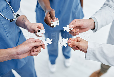 Buy stock photo Closeup shot of a group of medical practitioners holding puzzle pieces