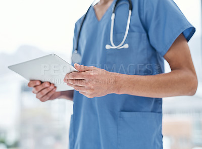 Buy stock photo Closeup shot of a medical practitioner using a digital tablet in a hospital