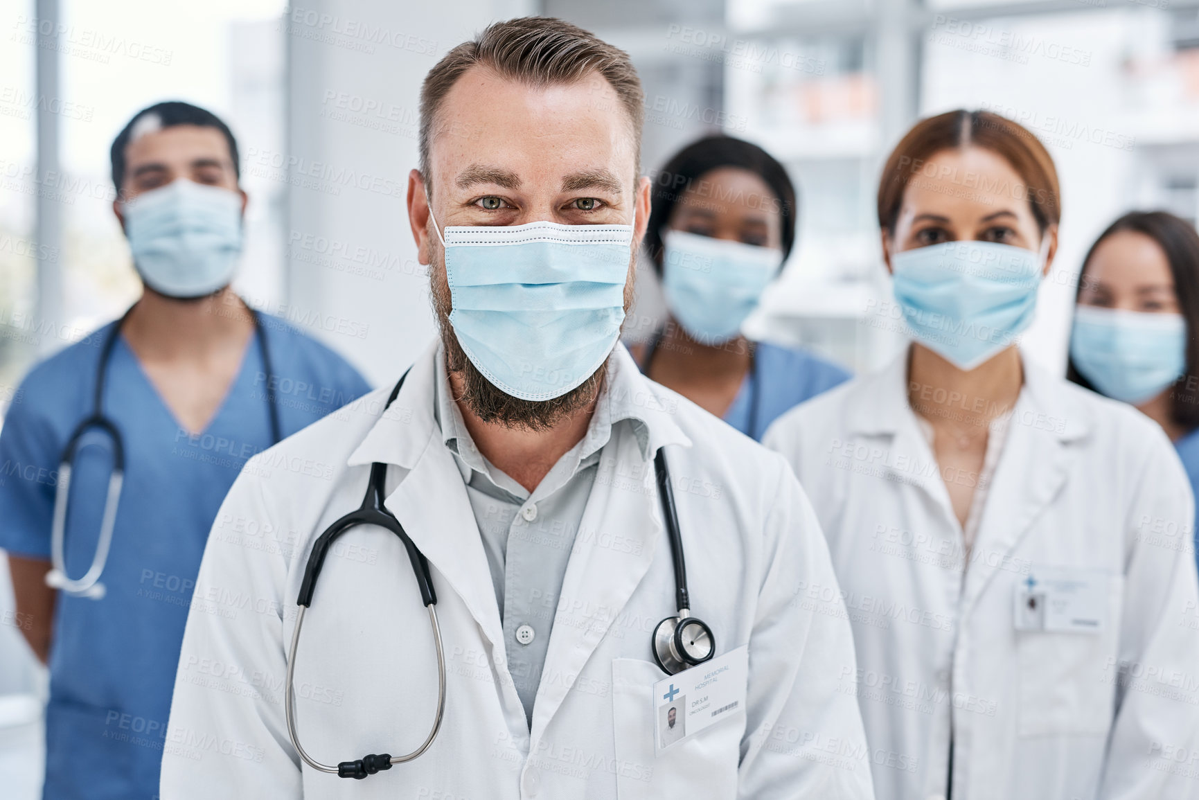 Buy stock photo Portrait of a group of medical practitioners wearing face masks in a hospital