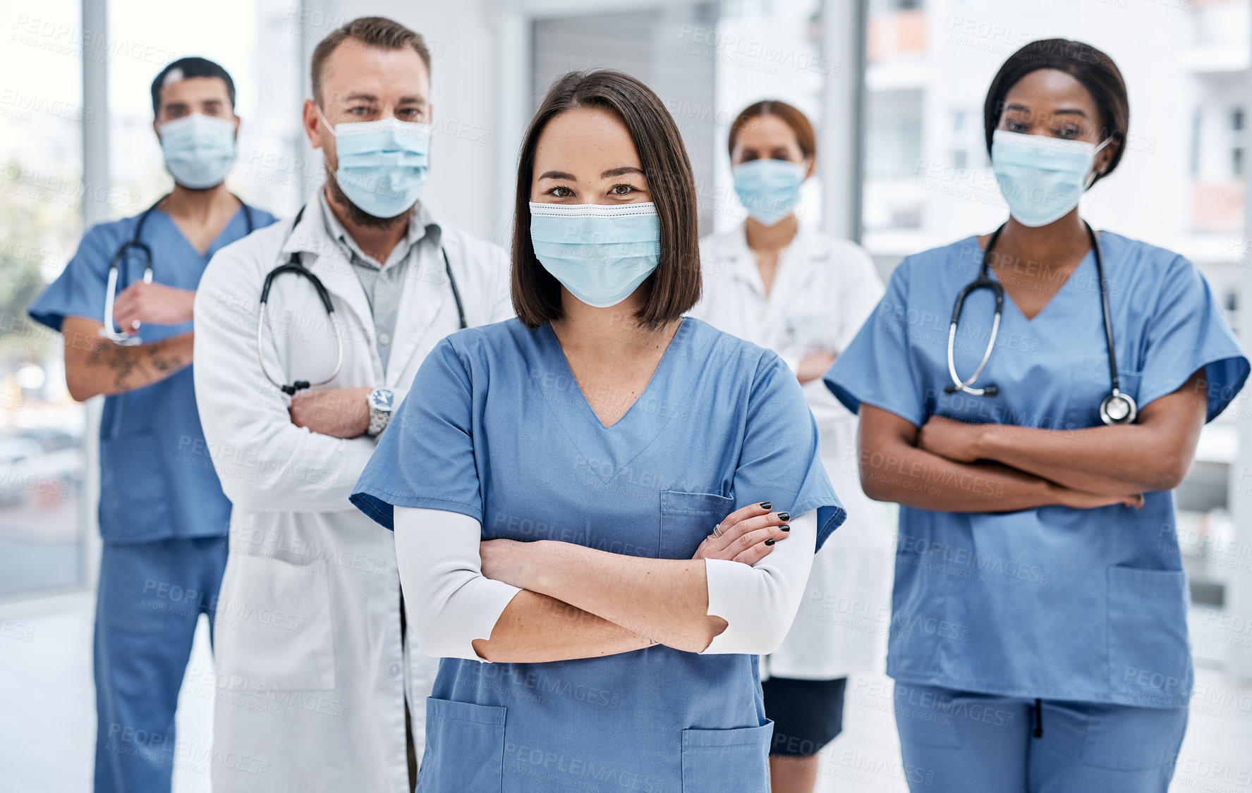 Buy stock photo Portrait of a group of medical practitioners wearing face masks in a hospital