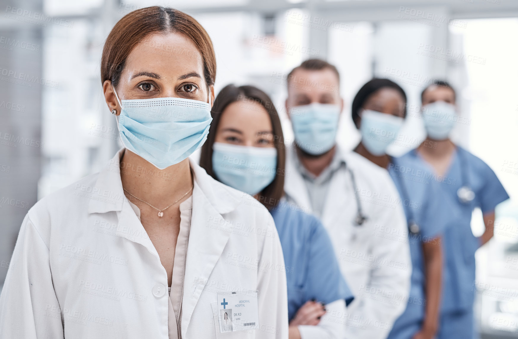 Buy stock photo Portrait of a group of medical practitioners wearing face masks in a hospital