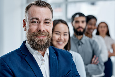 Buy stock photo Portrait of a businessman standing in an office with his colleagues in the background