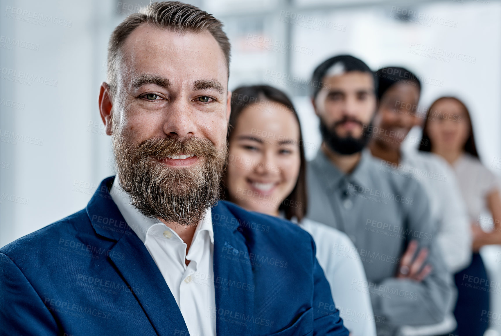 Buy stock photo Portrait of a businessman standing in an office with his colleagues in the background