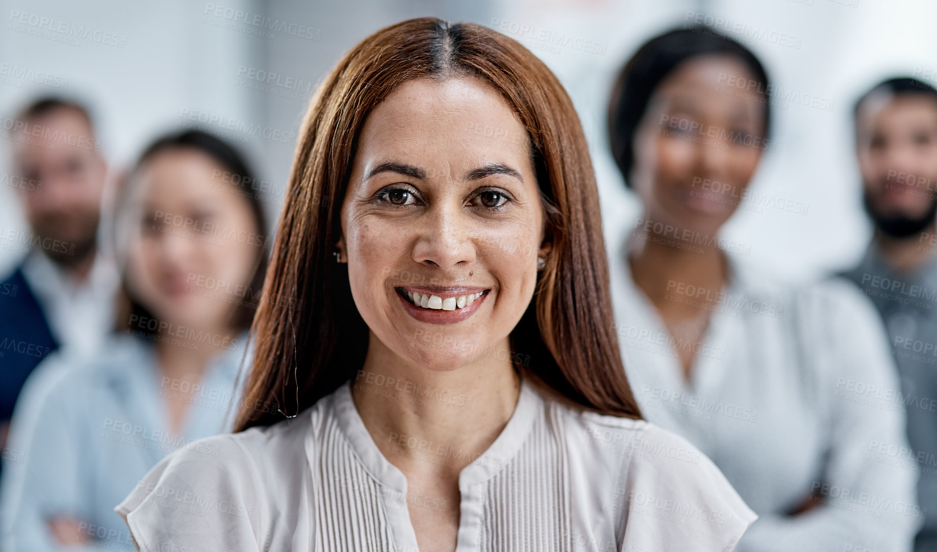 Buy stock photo Portrait of a businesswoman standing in an office with her colleagues in the background