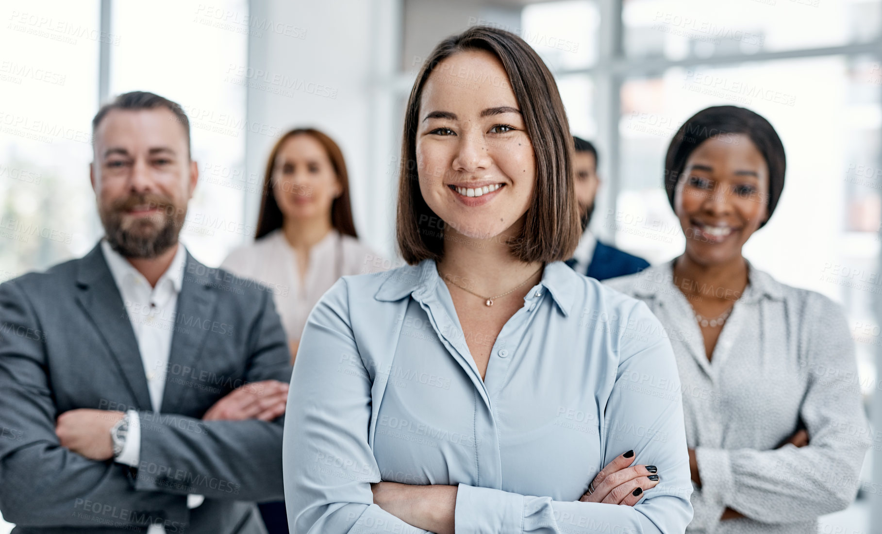 Buy stock photo Portrait of a businesswoman standing in an office with her colleagues in the background