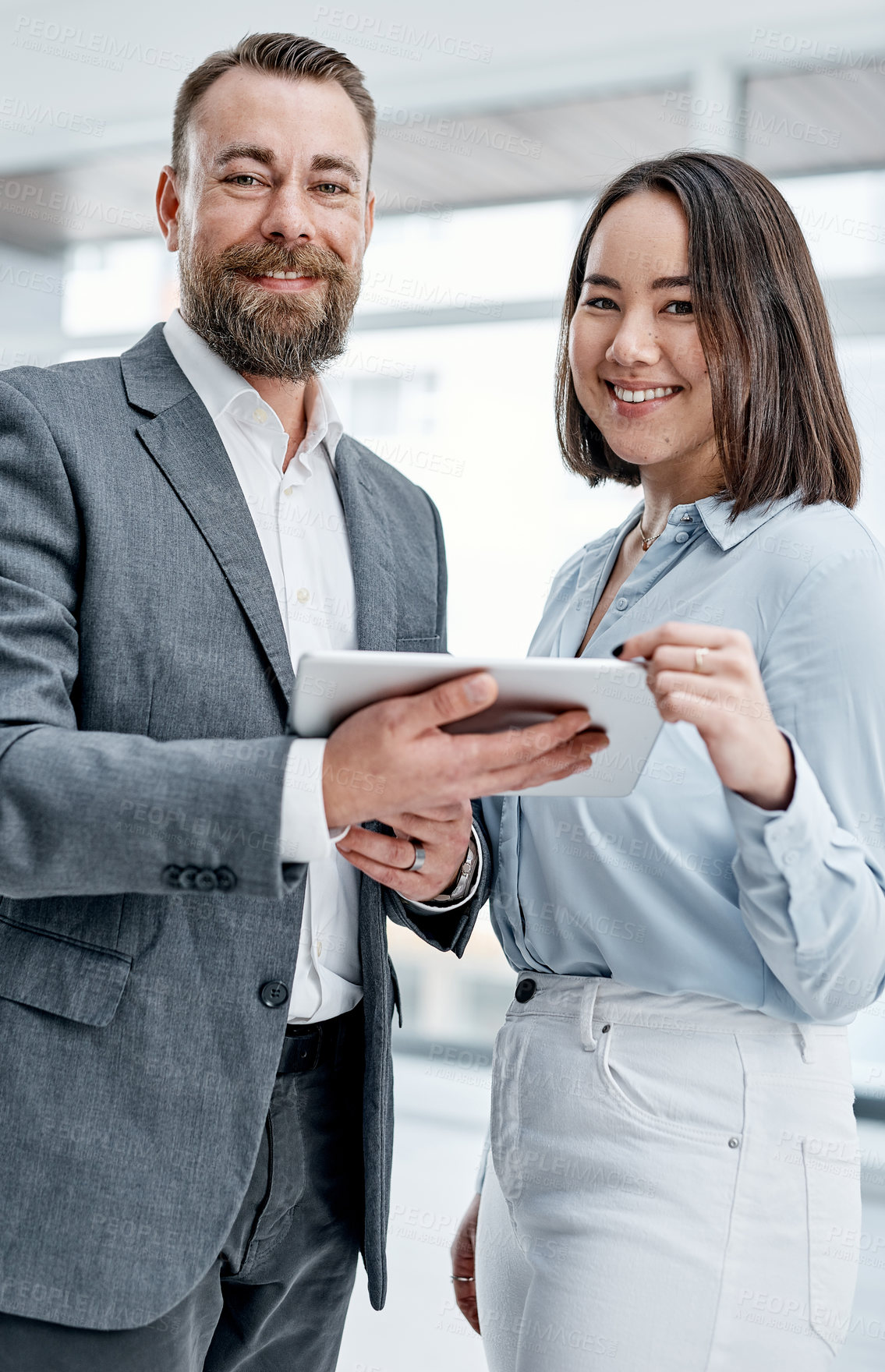 Buy stock photo Portrait of two businesspeople using a digital tablet together in an office