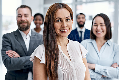 Buy stock photo Portrait of a businesswoman standing in an office with her colleagues in the background