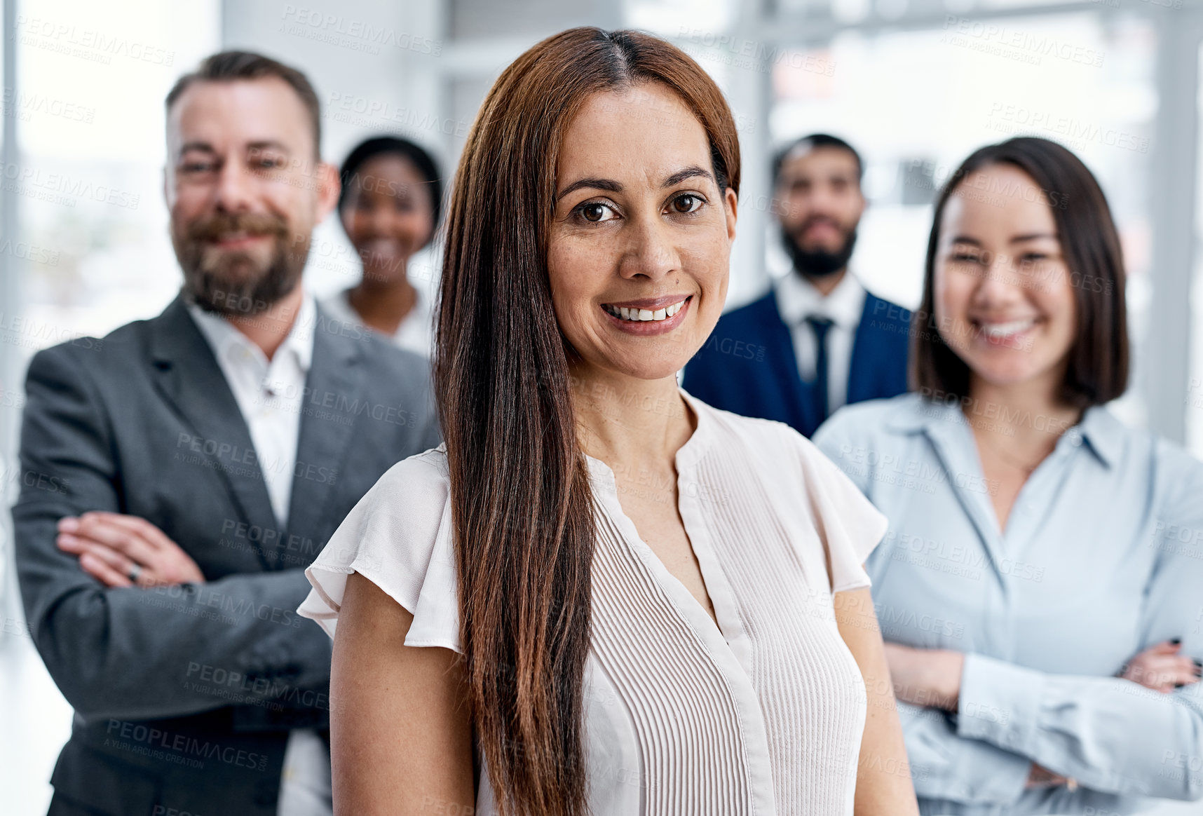 Buy stock photo Portrait of a businesswoman standing in an office with her colleagues in the background