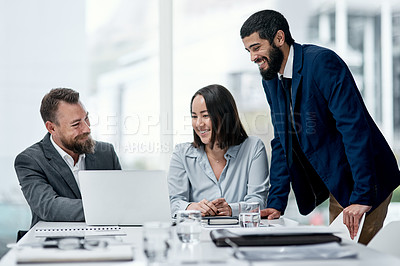 Buy stock photo Shot of a group of businesspeople working together on a laptop in an office