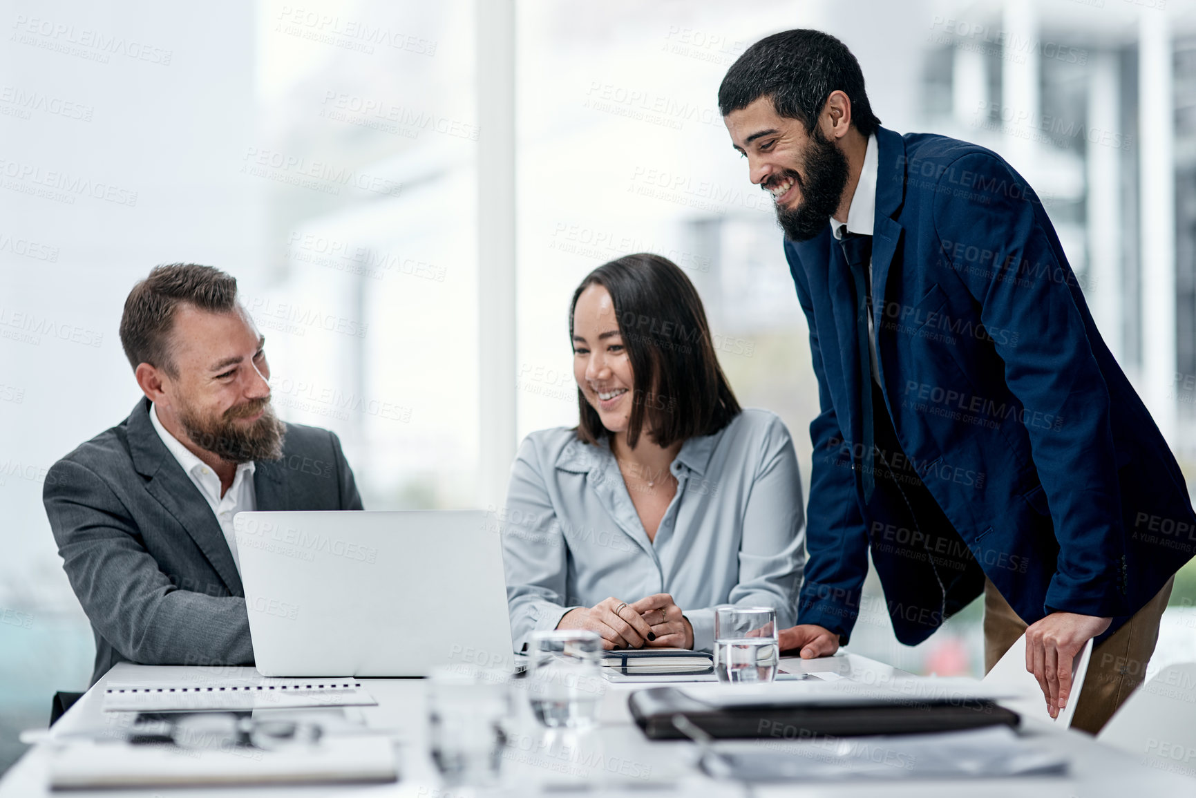 Buy stock photo Shot of a group of businesspeople working together on a laptop in an office