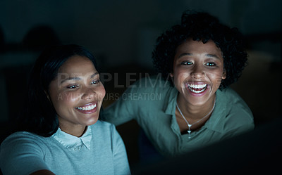 Buy stock photo Shot of two young businesswomen using a computer together during a late night at work