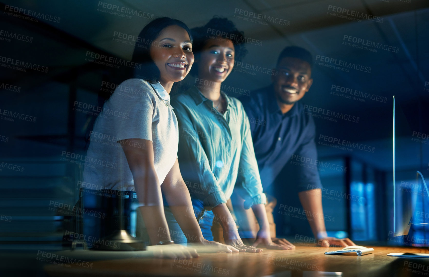 Buy stock photo Portrait of a group of young businesspeople using a computer together during a late night at work