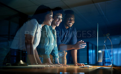 Buy stock photo Shot of a group of young businesspeople using a computer together during a late night at work