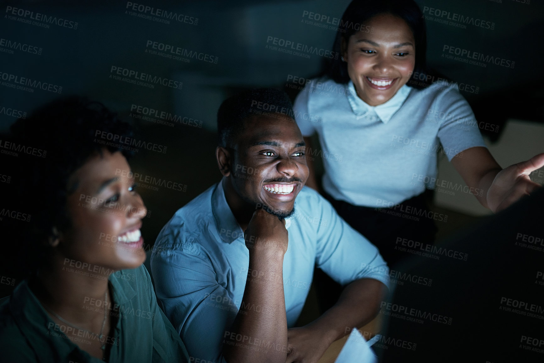 Buy stock photo Shot of a group of young businesspeople using a computer together during a late night at work