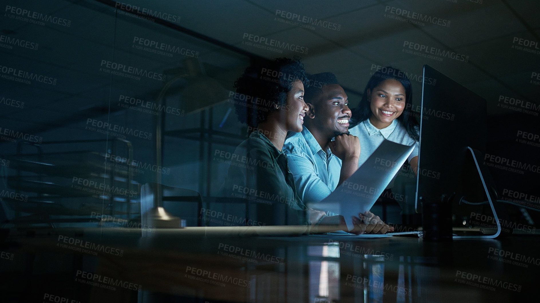 Buy stock photo Shot of a group of young businesspeople using a computer together during a late night at work