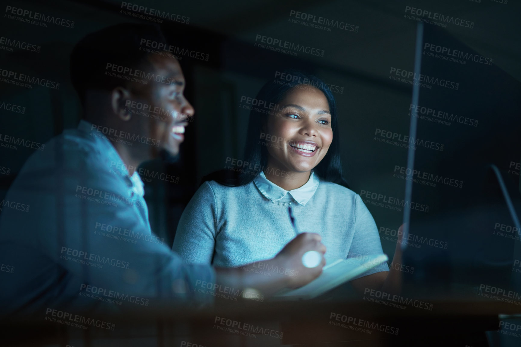 Buy stock photo Shot of a young businesswoman and businessman using a computer together during a late night at work