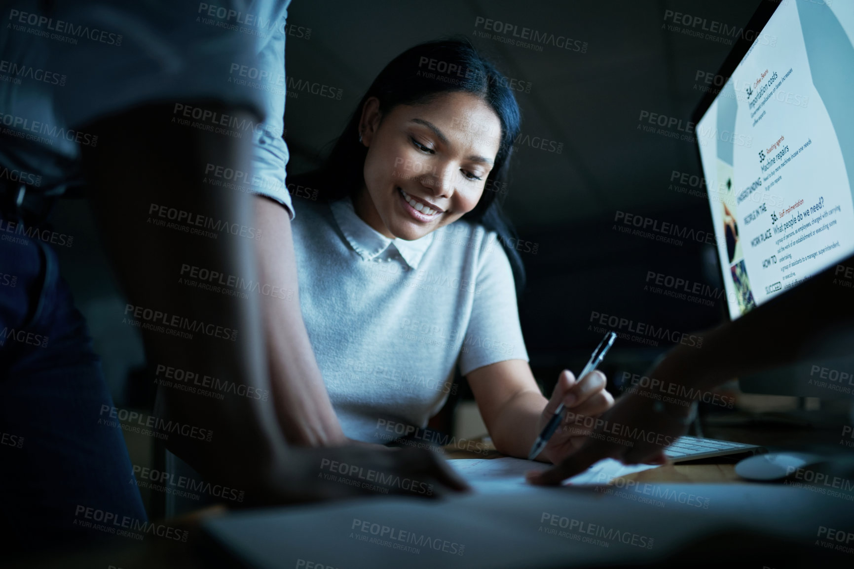 Buy stock photo Shot of a group of young businesspeople using a computer during a late night meeting at work