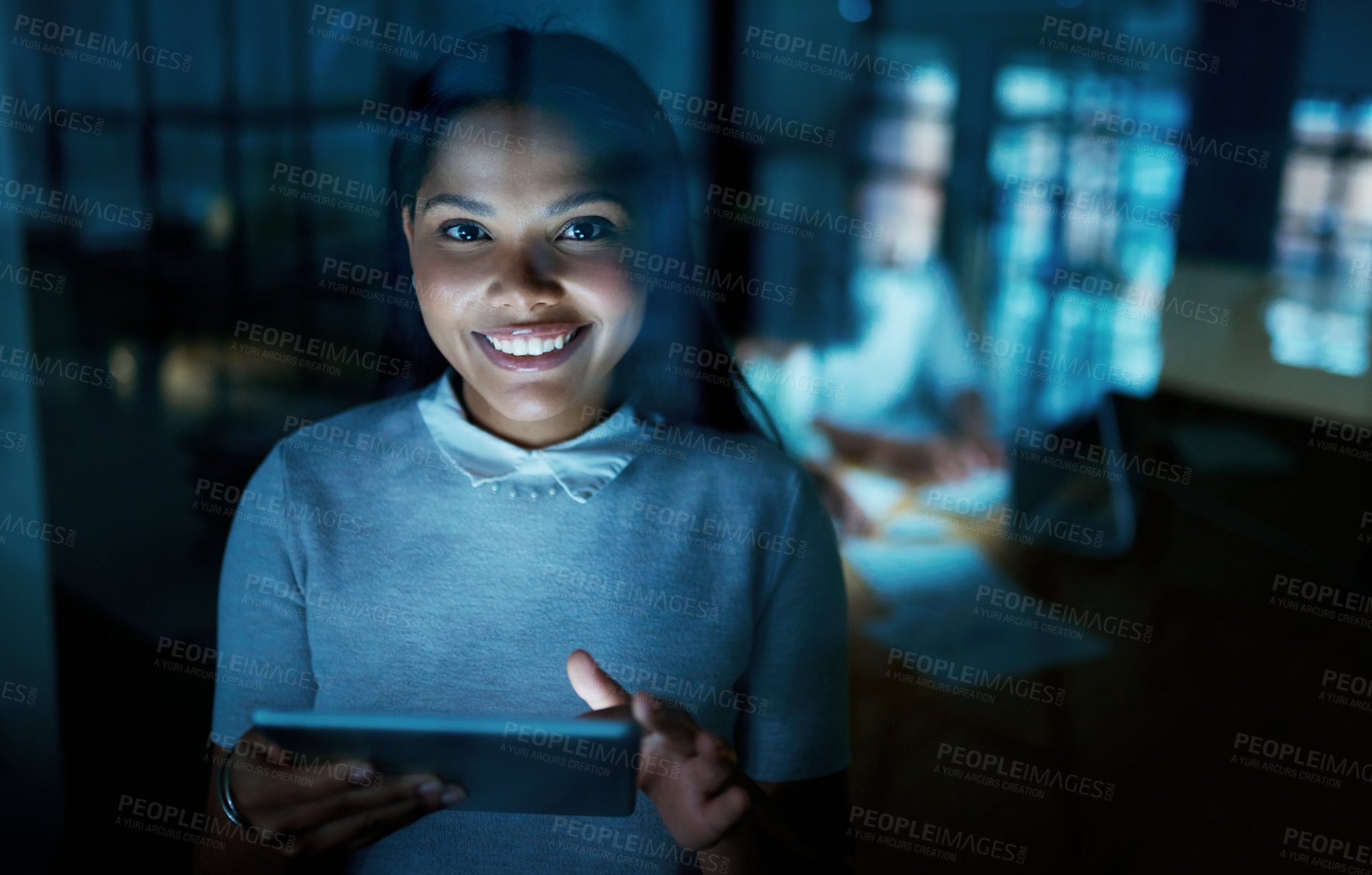 Buy stock photo Shot of a young businesswoman using a digital tablet during a late night at work