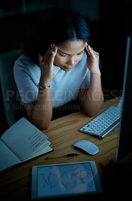 Buy stock photo Shot of a young businesswoman looking stressed while using a computer during a late night at work