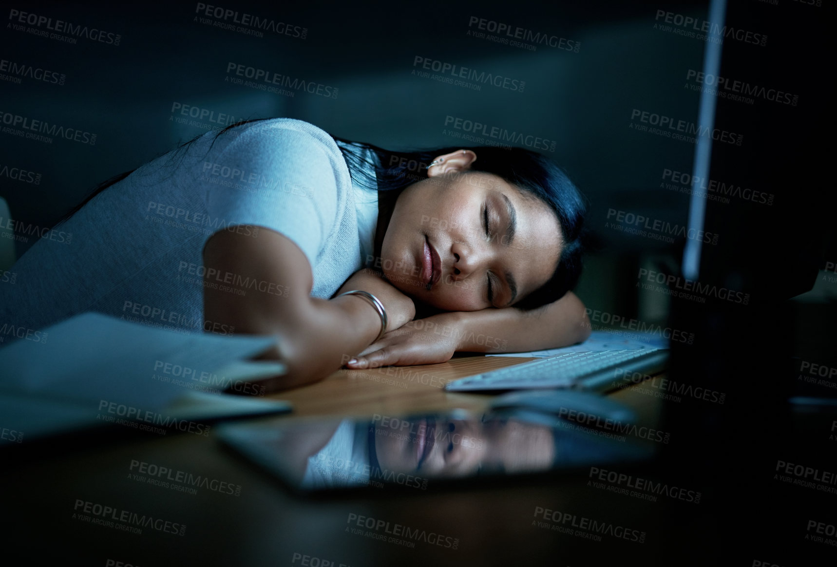 Buy stock photo Shot of young businesswoman sleeping at her desk during a late night in a modern office