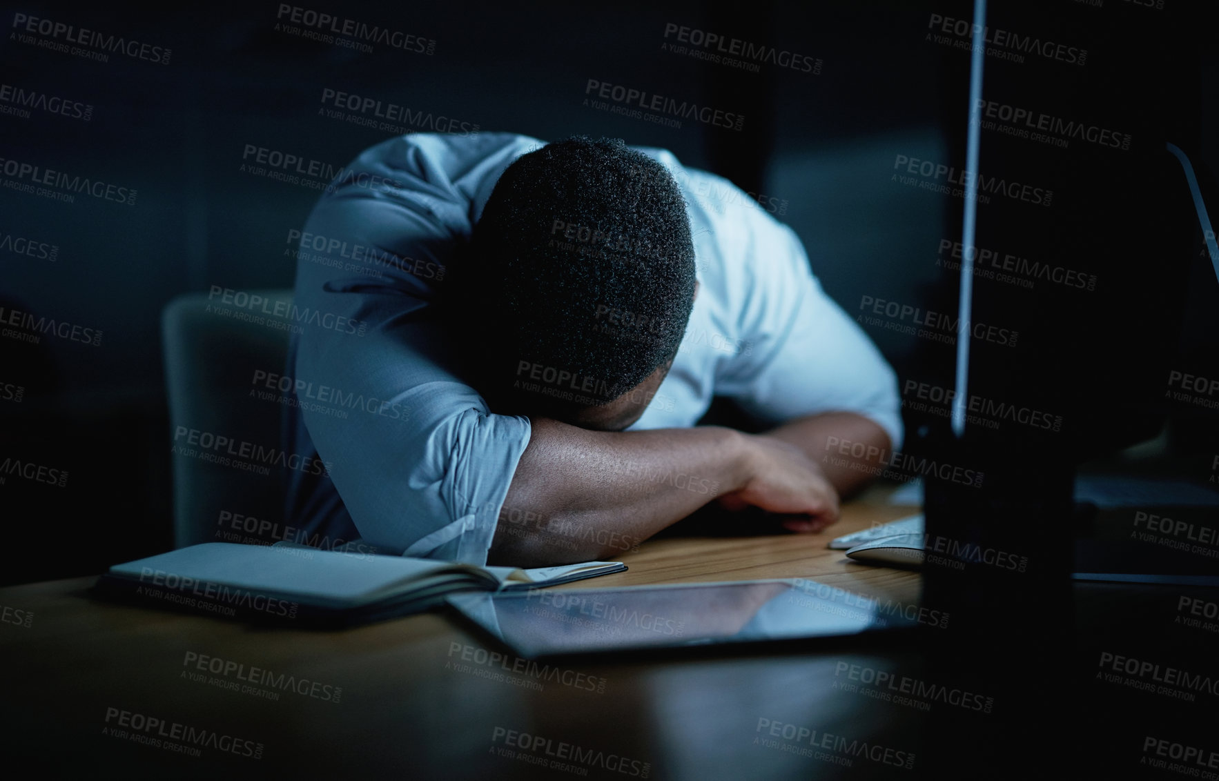 Buy stock photo Shot of young businessman sleeping at his desk during a late night in a modern office