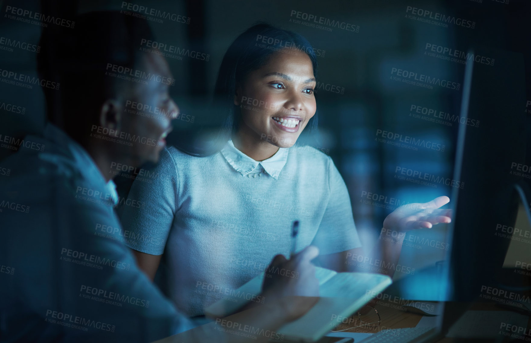 Buy stock photo Shot of a young businesswoman and businessman using a computer together during a late night at work