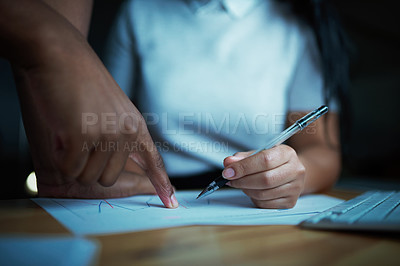 Buy stock photo Shot of unrecognisable businesspeople analysing financial reports during a late night at work