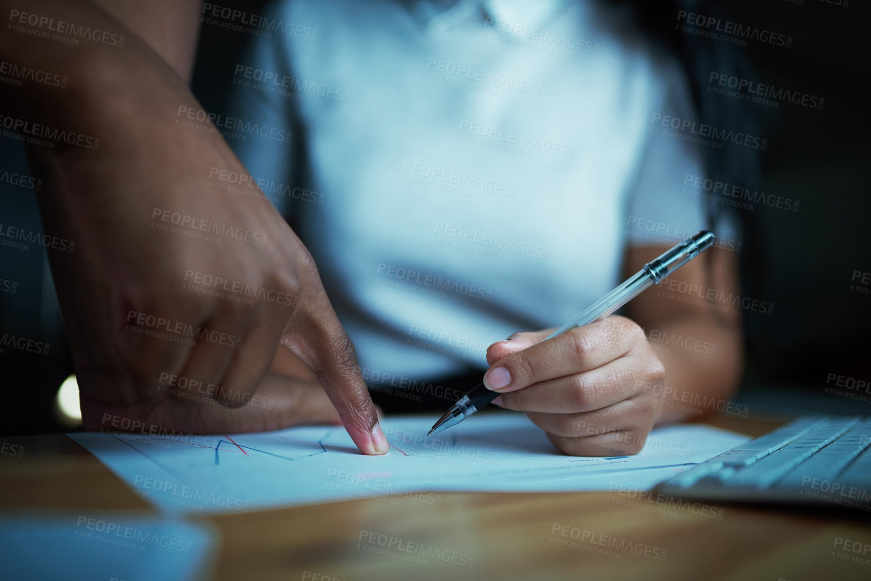 Buy stock photo Shot of unrecognisable businesspeople analysing financial reports during a late night at work