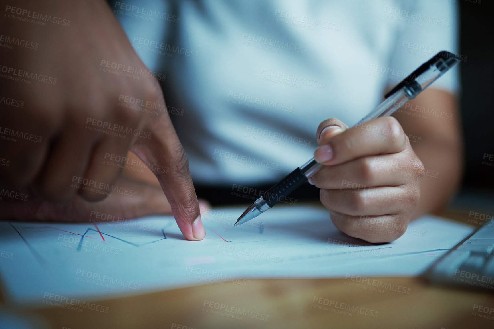 Buy stock photo Shot of unrecognisable businesspeople analysing financial reports during a late night at work